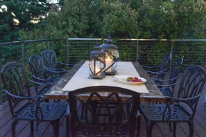 Enjoy dining al fresco with a beautifully set table for six, surrounded by lush greenery.