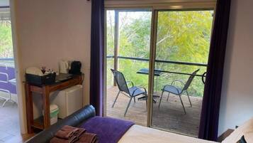 Una stanza con un letto, una scrivania e un balcone con sedie.