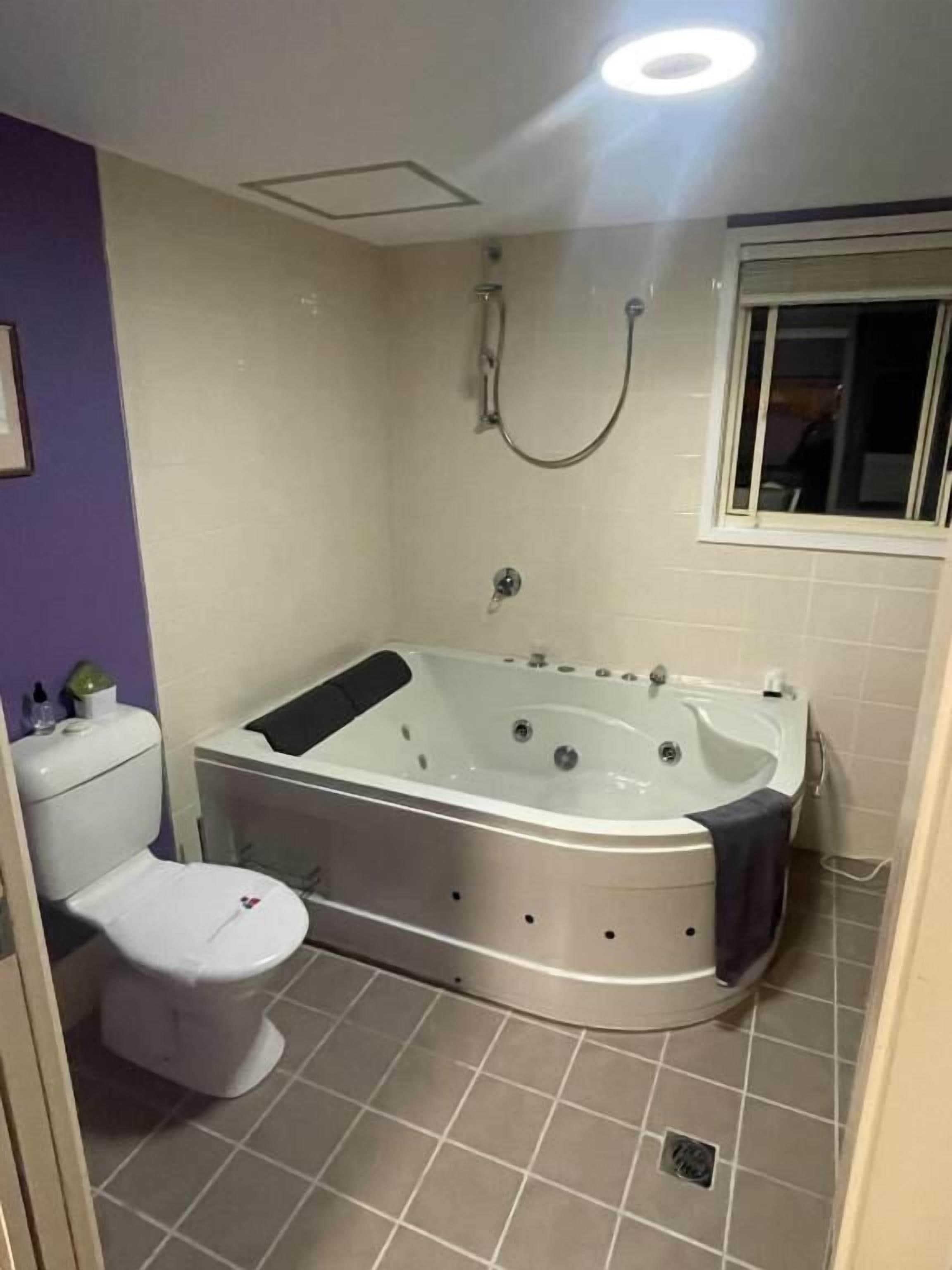 A bathroom with a bathtub, toilet, and shower.