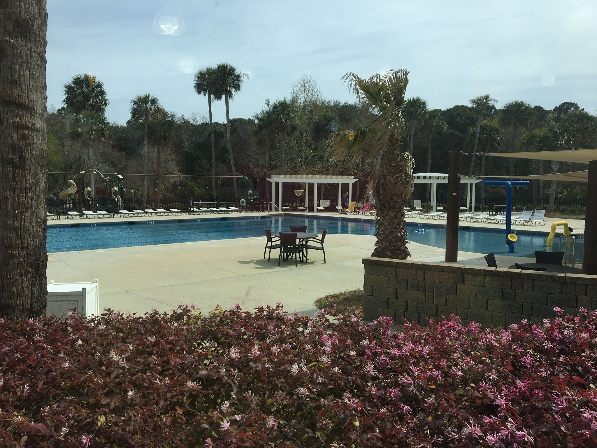 A swimming pool with lounge chairs and a covered seating area.