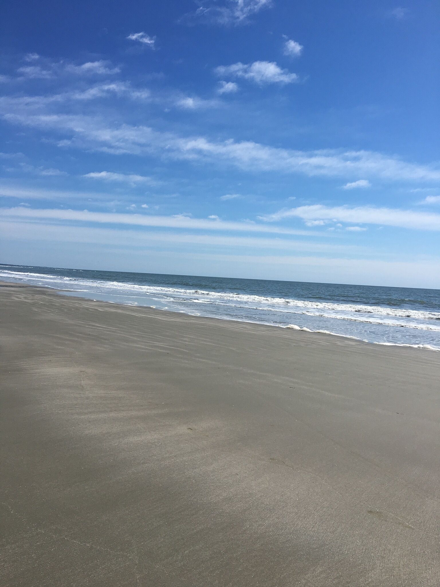 A beach with a clear sky and gentle waves.