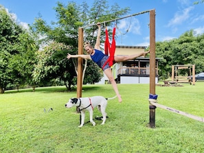 Una persona realizando una rutina de gimnasia al aire libre, con un perro cerca.