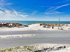 Eine Küstenstraße mit Sandstrand und Dünen.