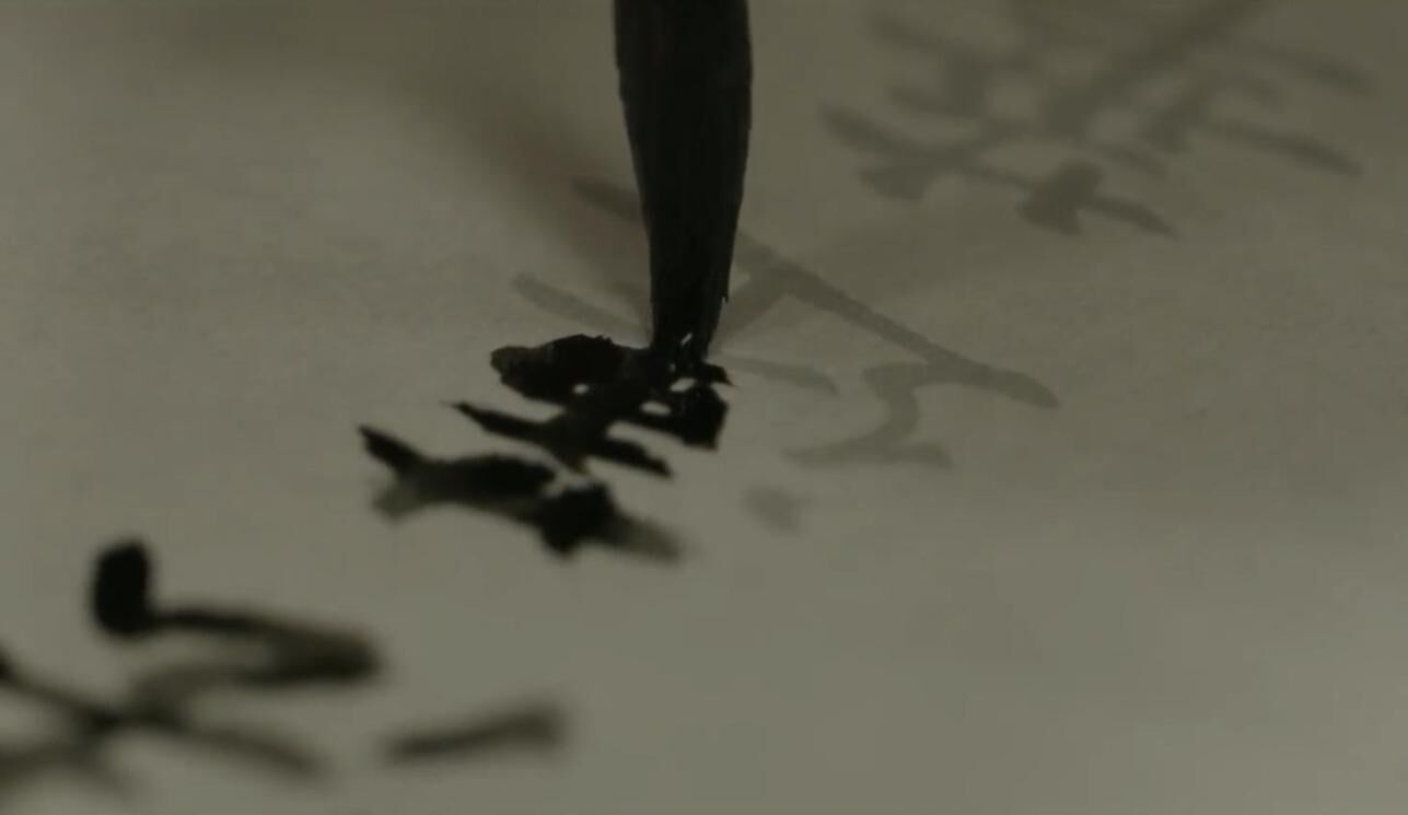 A close-up of a pen tip with ink on a surface.