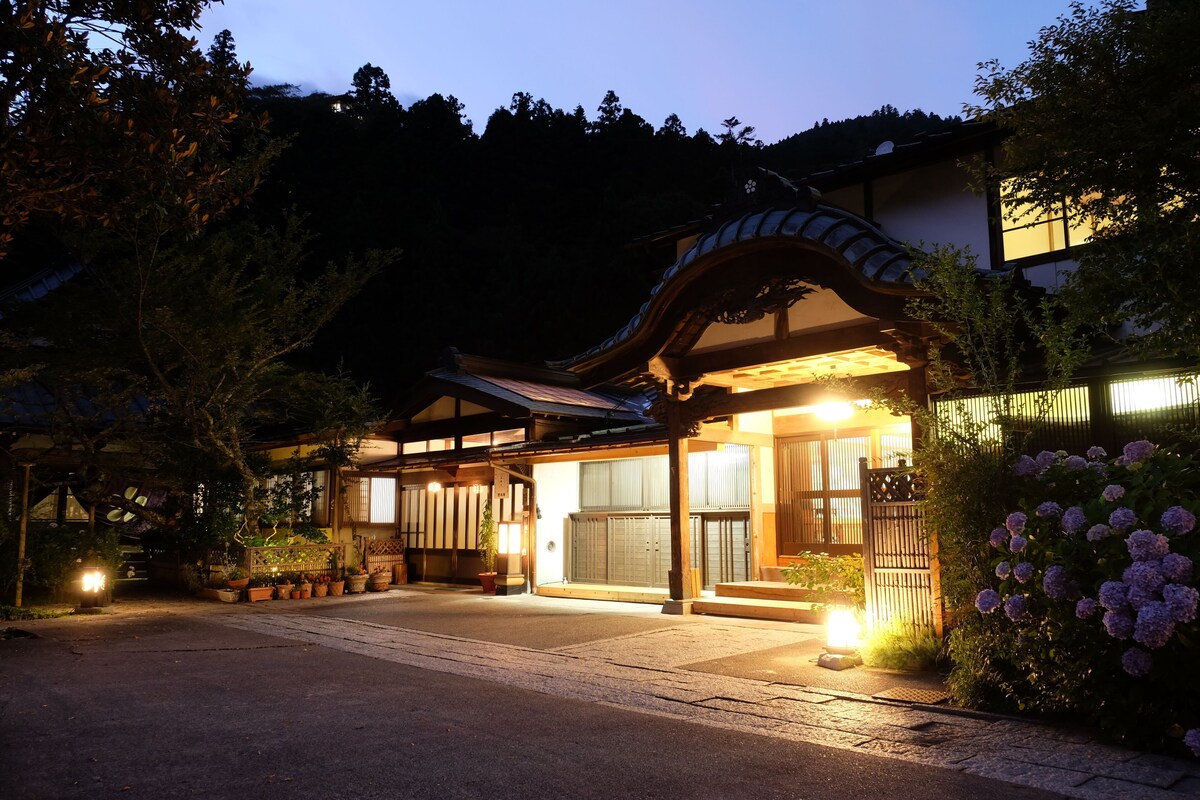 A traditional Japanese building with a wooden entrance and potted plants.