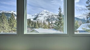 A room with a large window offering a view of a snow-covered mountain and forested area. - Cabin w/ Hot Tub & Views: 1 Mile to Alyeska Resort (Girdwood)