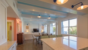 A spacious kitchen with a large island, wooden flooring, and a view through the window. - A Sunset & Harbour View at The Truman Annex in Key West (Key West)