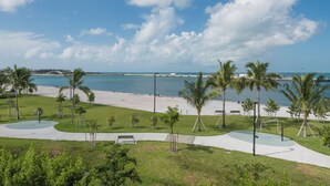 A beachside park with palm trees, a playground, and a view of the ocean. - A Sunset & Harbour View at The Truman Annex in Key West (Key West)