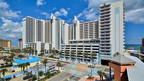 A high-rise hotel with multiple floors, a parking garage, and a view of the ocean.