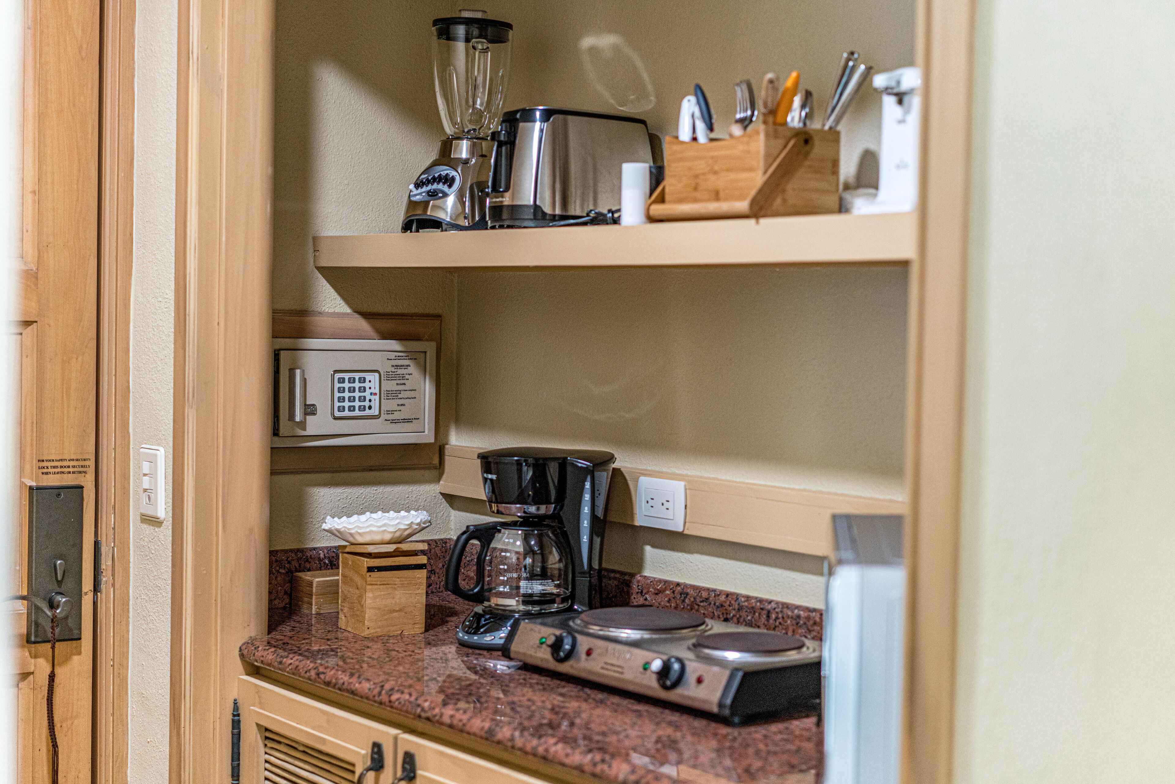 Una cocina con microondas, cafetera y estufa.