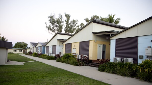 A row of modern, single-story buildings with a uniform design, featuring large windows and air conditioning units. - The Three Ways Alligator Creek (Alligator Creek)