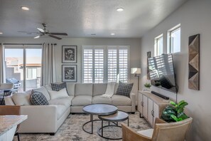 Relax in this inviting living room with a beige sofa, round coffee table, and wicker chair.