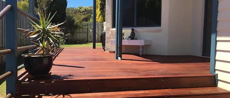 A wooden deck with steps leading to a house.