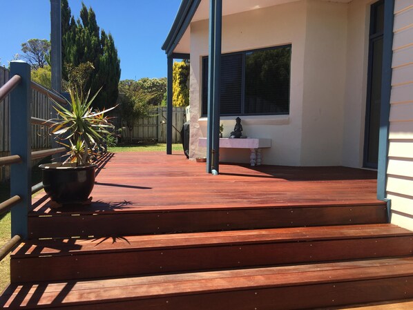 A wooden deck with steps leading to a house.
