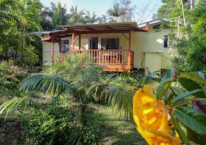 Surrounded by lush tropical vegetation, this charming building features a simple design with a flat roof and a small window.