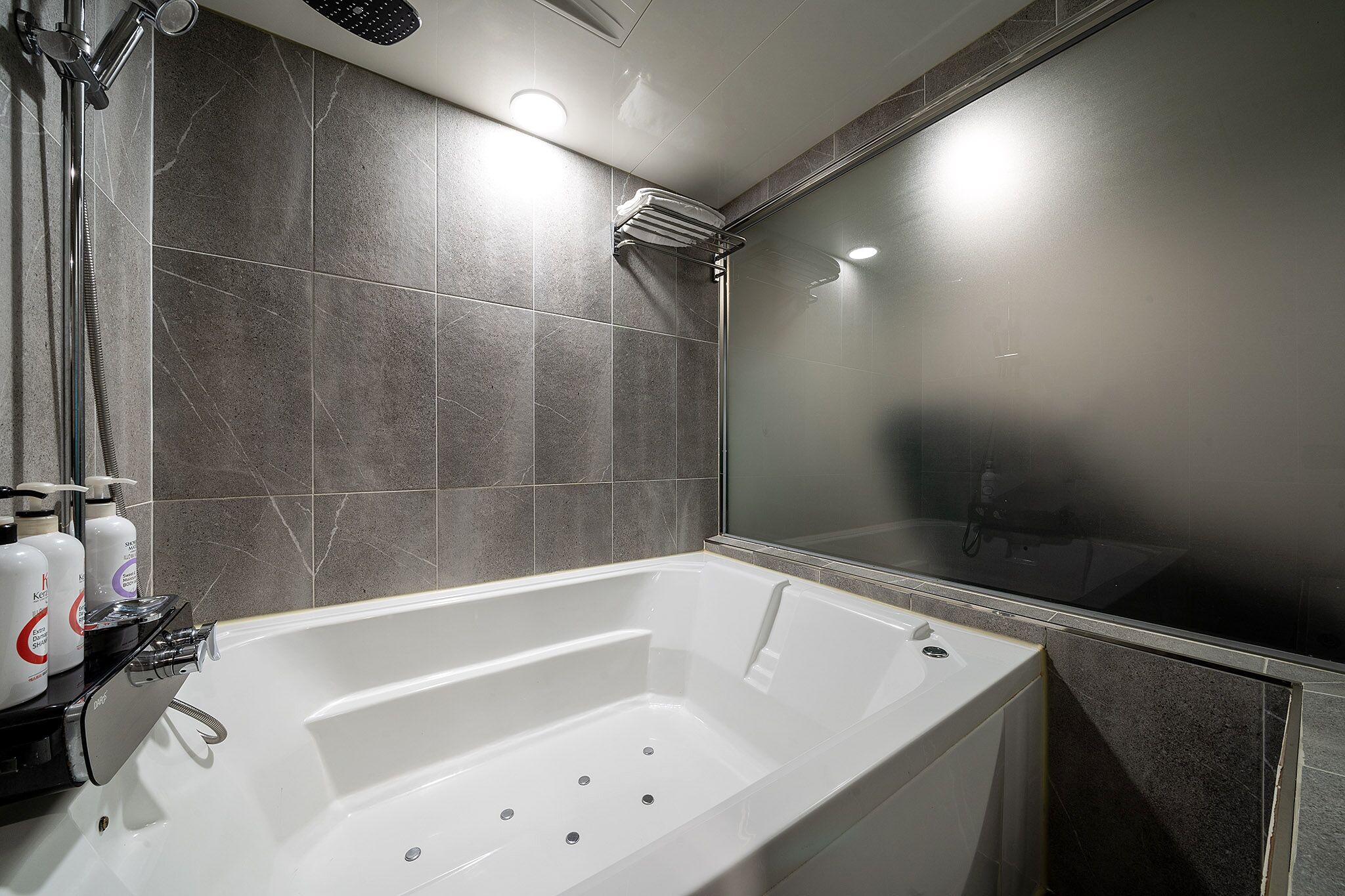 Un baño moderno con bañera, ducha y zona de ducha con paredes de vidrio.