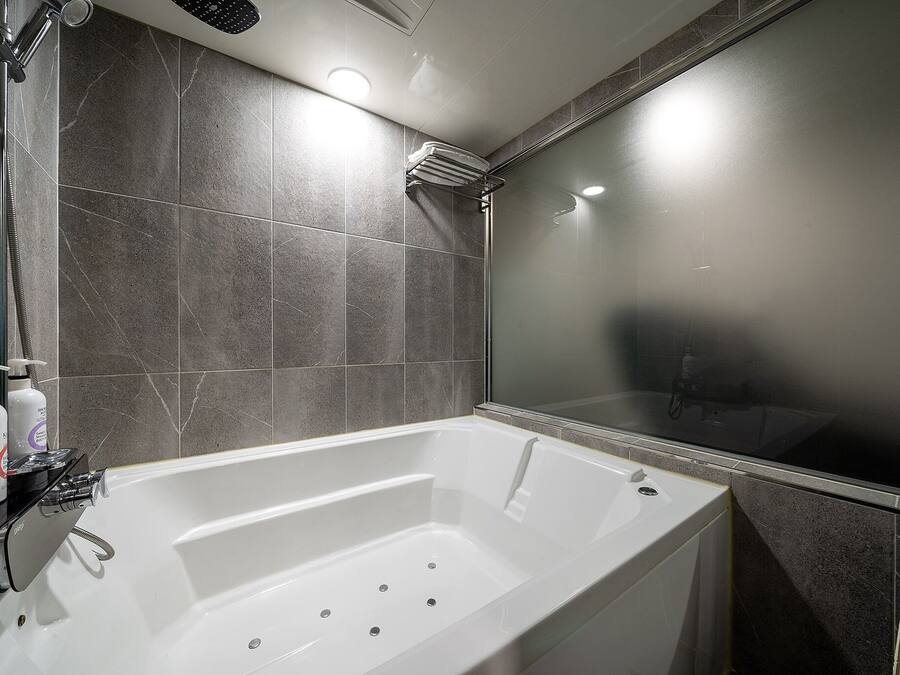 Un baño moderno con bañera, ducha y zona de ducha con paredes de vidrio.