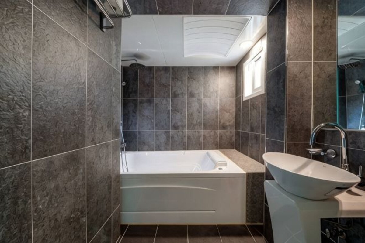 A bathroom with a bathtub, a sink, and a shower.