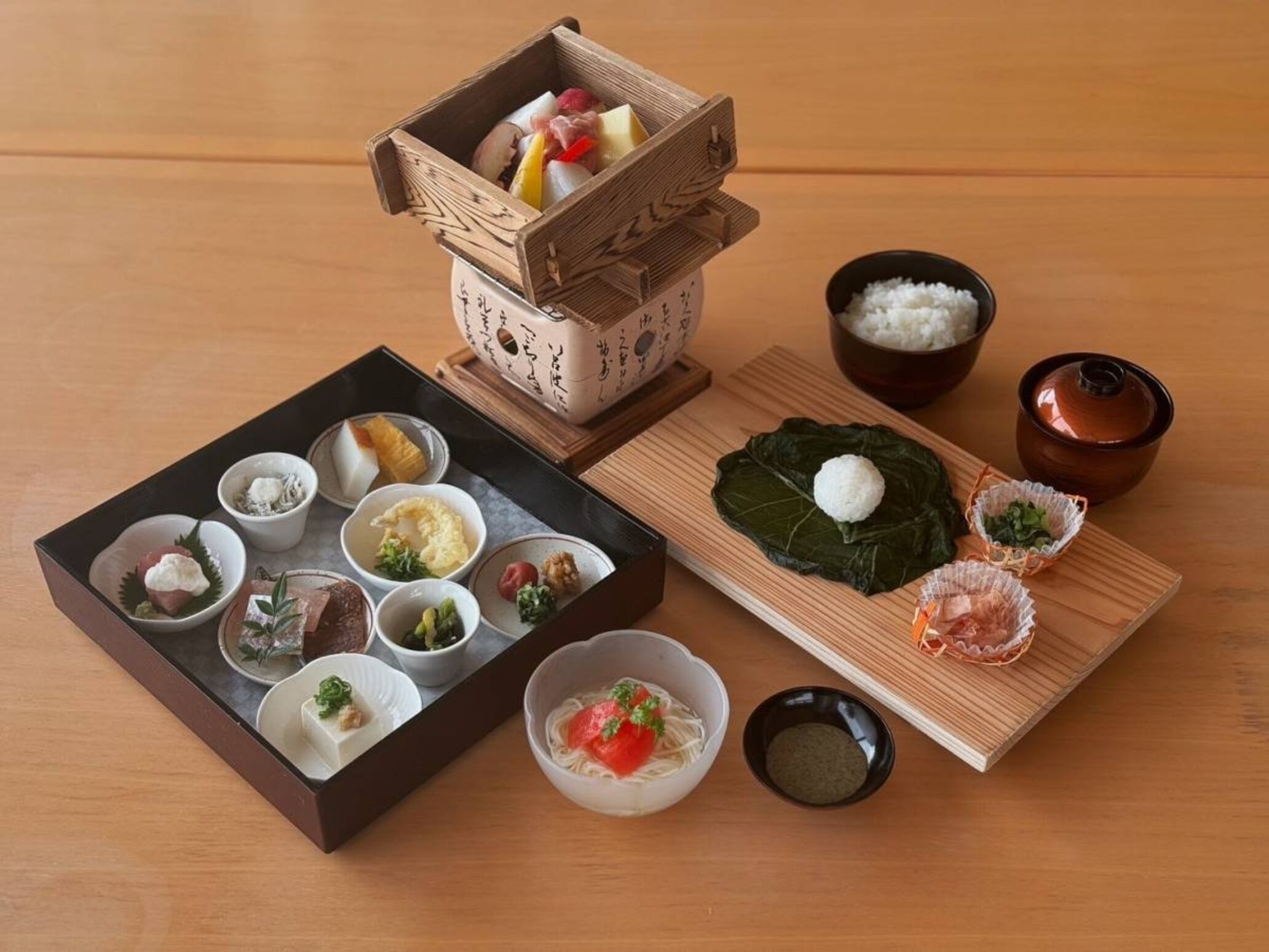 A traditional Japanese meal setup with various dishes including rice, fish, and vegetables.