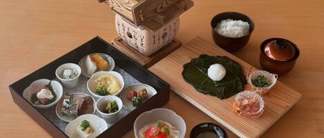 A traditional Japanese meal setup with various dishes including rice, fish, and vegetables.