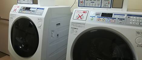 Twee voorladers wasmachines met bedieningspanelen en gebruiksaanwijzingen.