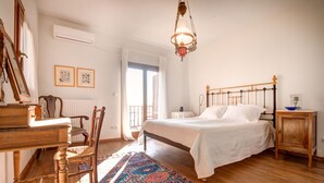 A bedroom with a wooden bed, a nightstand, a chair, a desk, and a patterned rug. - Breathtaking Panoramic Sea View.Private swimming pool  4,5 m X 11 m! (Kato Agios Petros)
