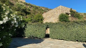 A stone pathway leading to a stone building surrounded by well-maintained hedges. - Breathtaking Panoramic Sea View.Private swimming pool  4,5 m X 11 m! (Kato Agios Petros)