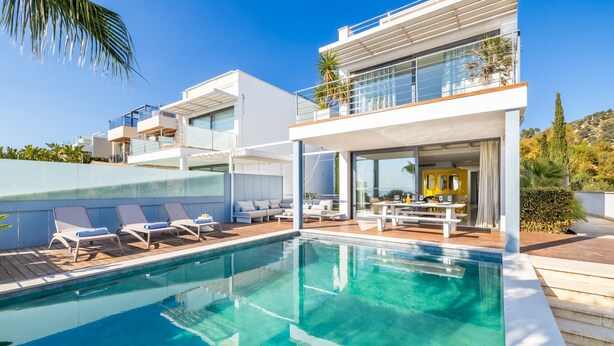 A modern poolside area with a clear pool, lounge chairs, and a contemporary outdoor seating area. - Designer Alcanada by Balearic Villas (Alcúdia)