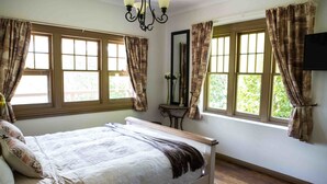A bedroom with a bed, curtains, a mirror, and a window. - Buttercuphill B&B (Warburton)