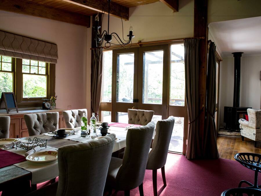 A dining area with a table set for four, surrounded by upholstered chairs.