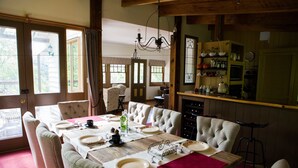 A dining area with a wooden table set for four, surrounded by upholstered chairs. - Buttercuphill B&B (Warburton)
