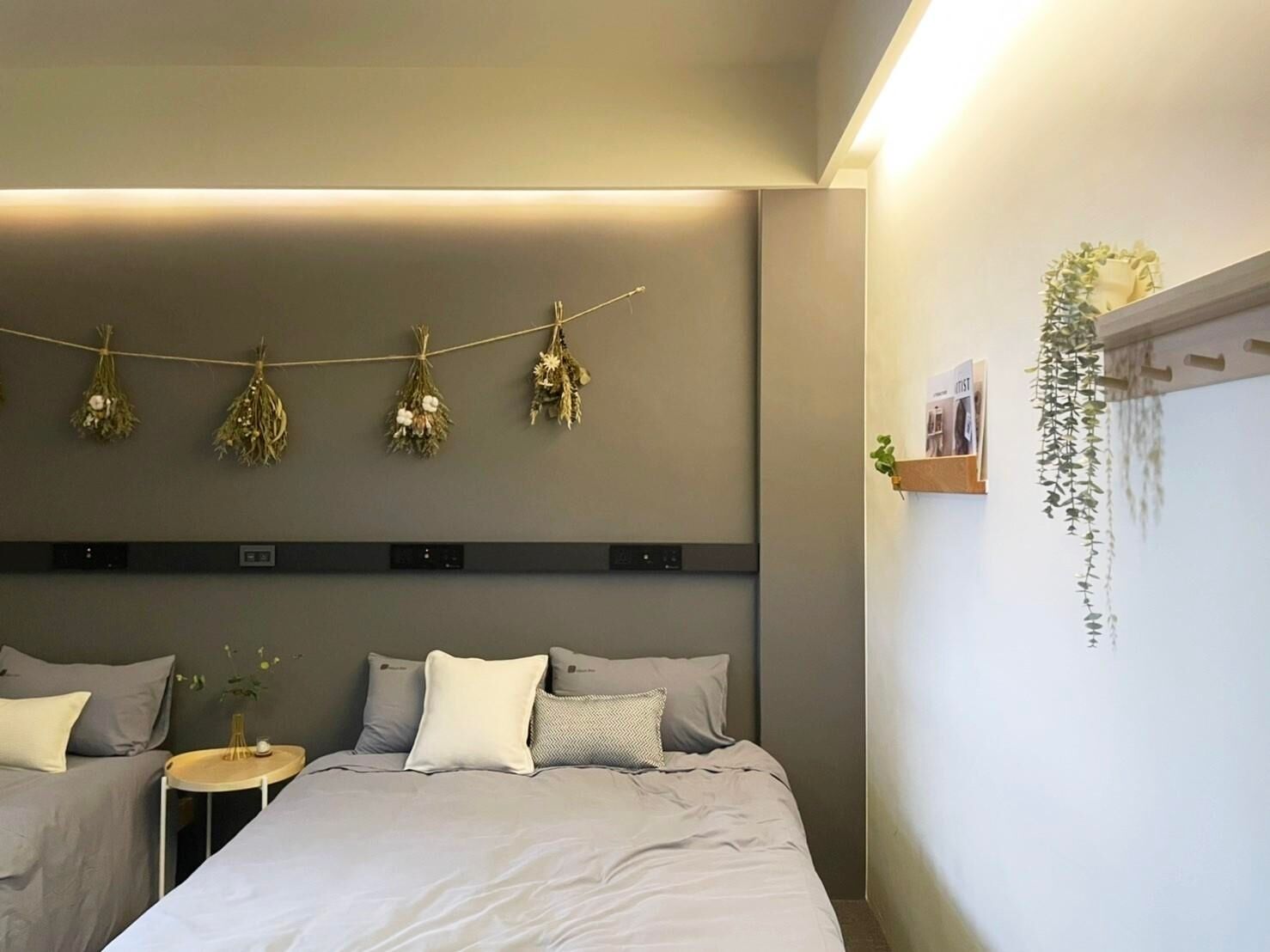 Un dormitorio moderno con cama, mesitas de noche y una lámpara fijada a la pared.
