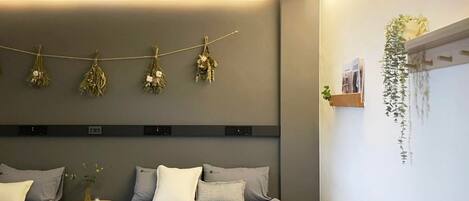 Un dormitorio moderno con cama, mesitas de noche y una lámpara fijada a la pared.