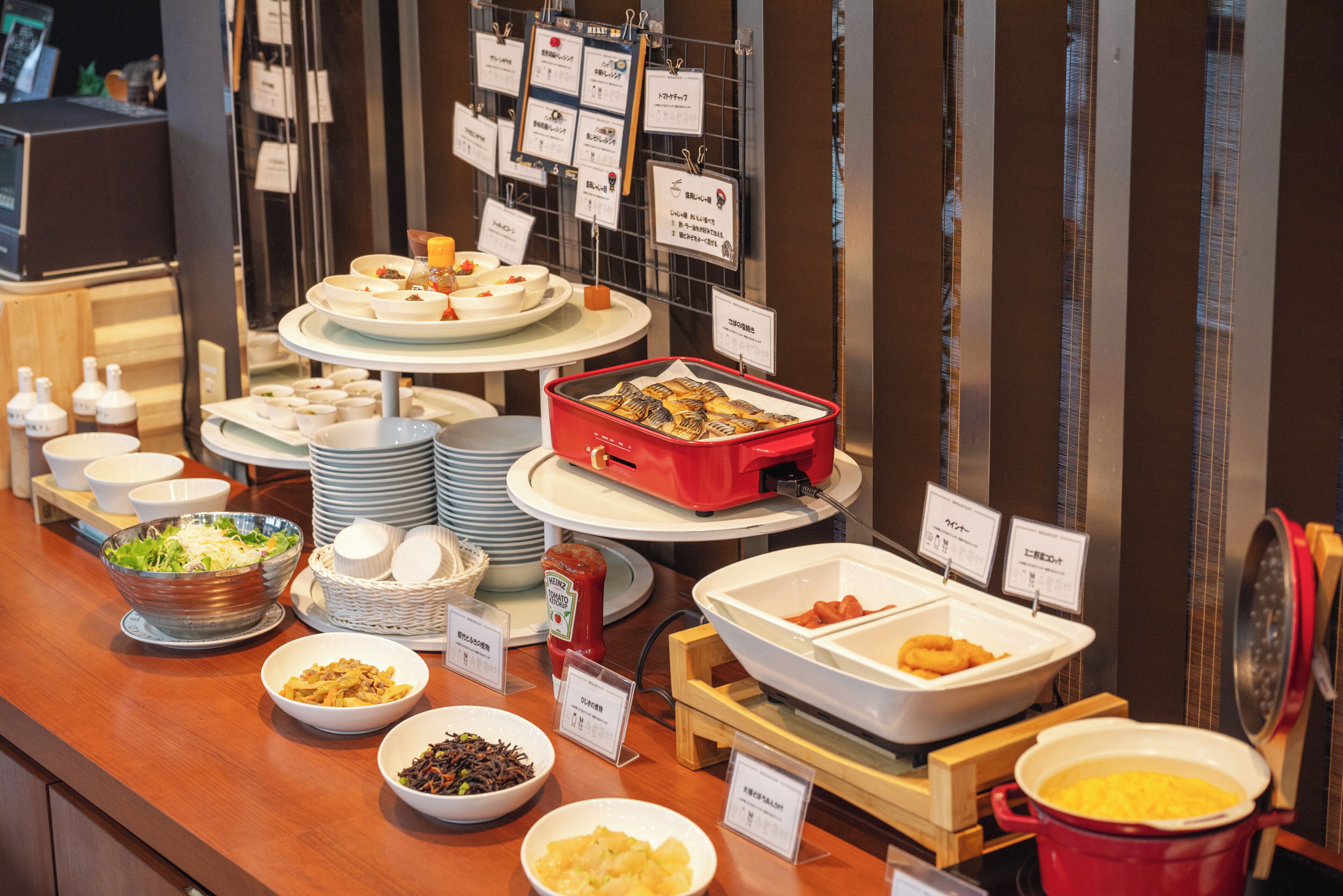 Buffet com diversos alimentos e etiquetas.