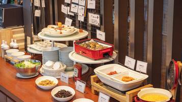 Buffet com diversos alimentos e etiquetas.