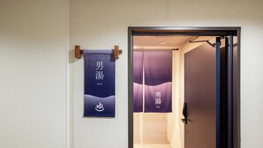 Une pièce avec une porte coulissante, une serviette accrochée au mur et une pancarte avec des caractères chinois.