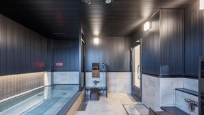 Une salle de bain moderne avec une paroi en verre, un espace douche et un lavabo.