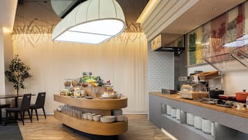A modern breakfast bar with a variety of food items and a coffee machine.