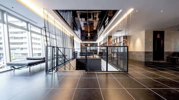 A modern interior with a glass railing, a staircase, and a view of the outside.