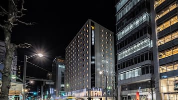 A modern hotel building with multiple floors, large windows, and a prominent sign for HOTEL VISTA.