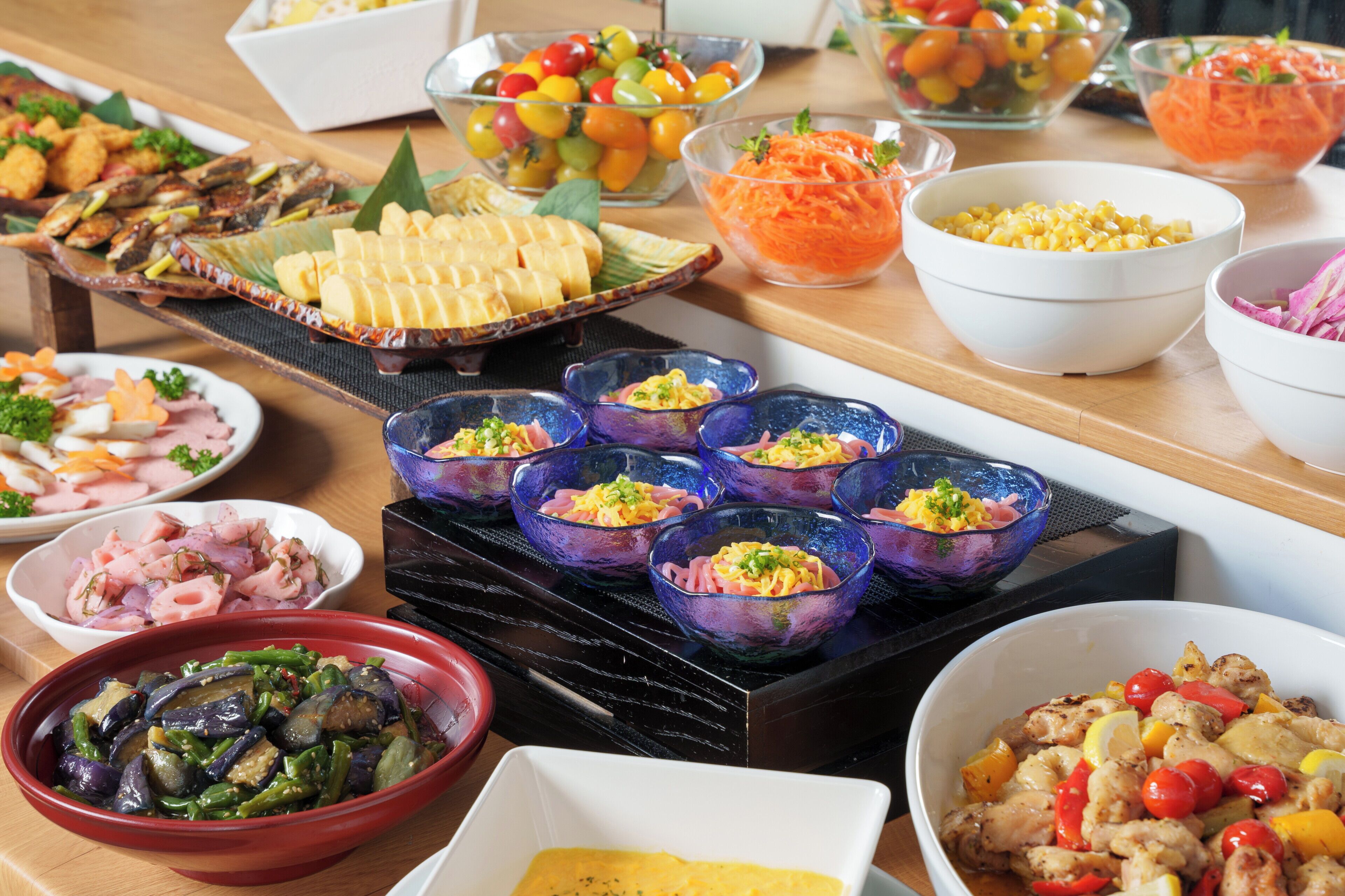 A buffet table with various dishes including salads, meats, and vegetables.