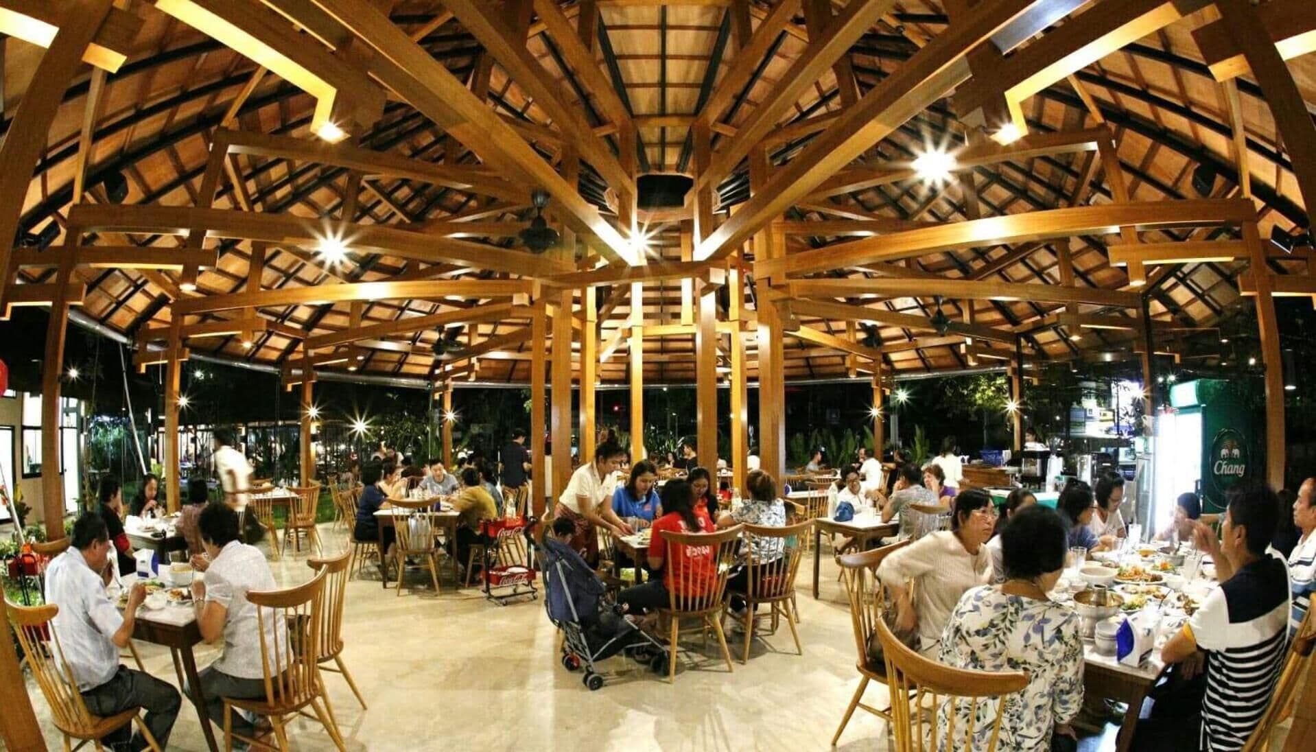 An indoor dining area with wooden beams and tables.