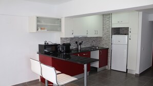 Una cocina compacta equipada con microondas, cafetera y refrigerador.