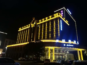 Un hotel con una entrada destacada y señalización iluminada.