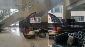 Un vestíbulo amplio con una escalera, zonas de estar y vistas al exterior.