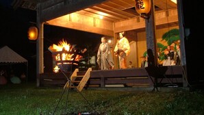 A wooden building with a stage and a fire.