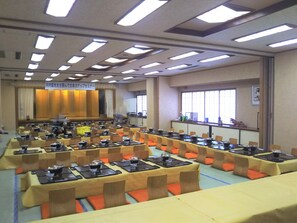 A conference room with multiple tables and chairs, equipped with nameplates and table settings. - Sado Ryotsu Shiizaki Onsen (Sado)