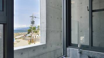 A bathroom with a large window, a bathtub, and a shower.