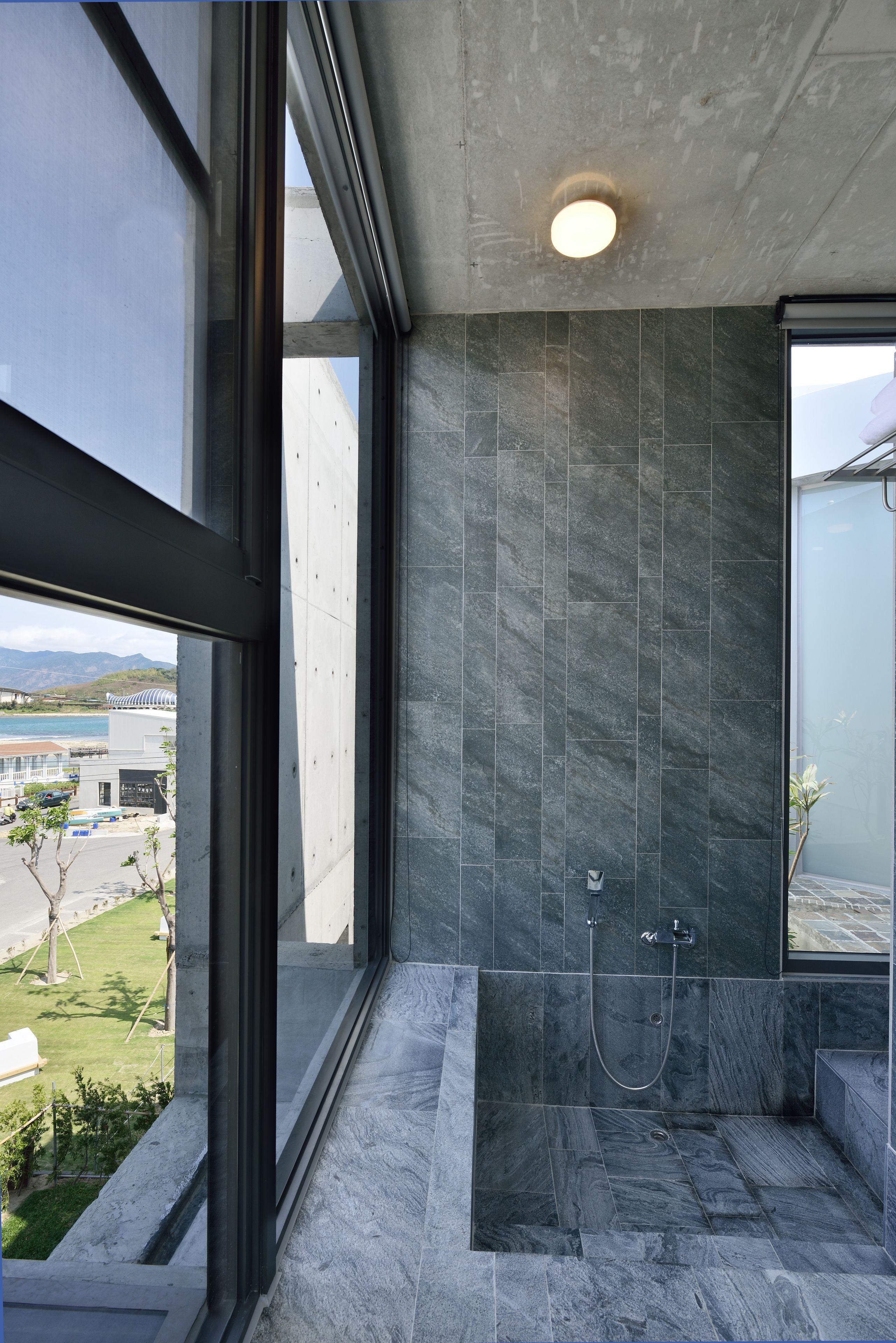 Un baño moderno con un ventanal grande, ducha integrada y vistas al exterior.