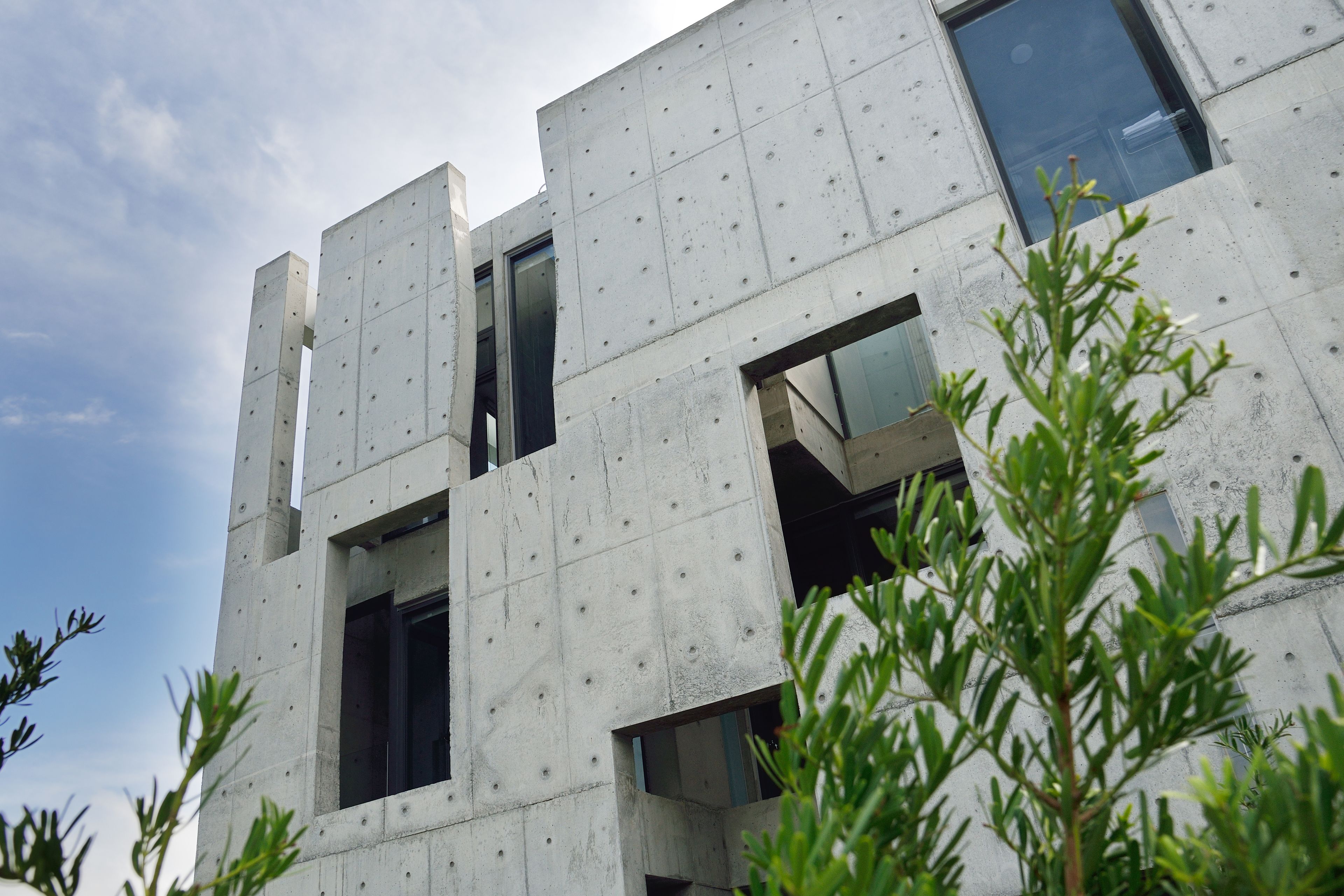 A modern building with a concrete facade and multiple windows.